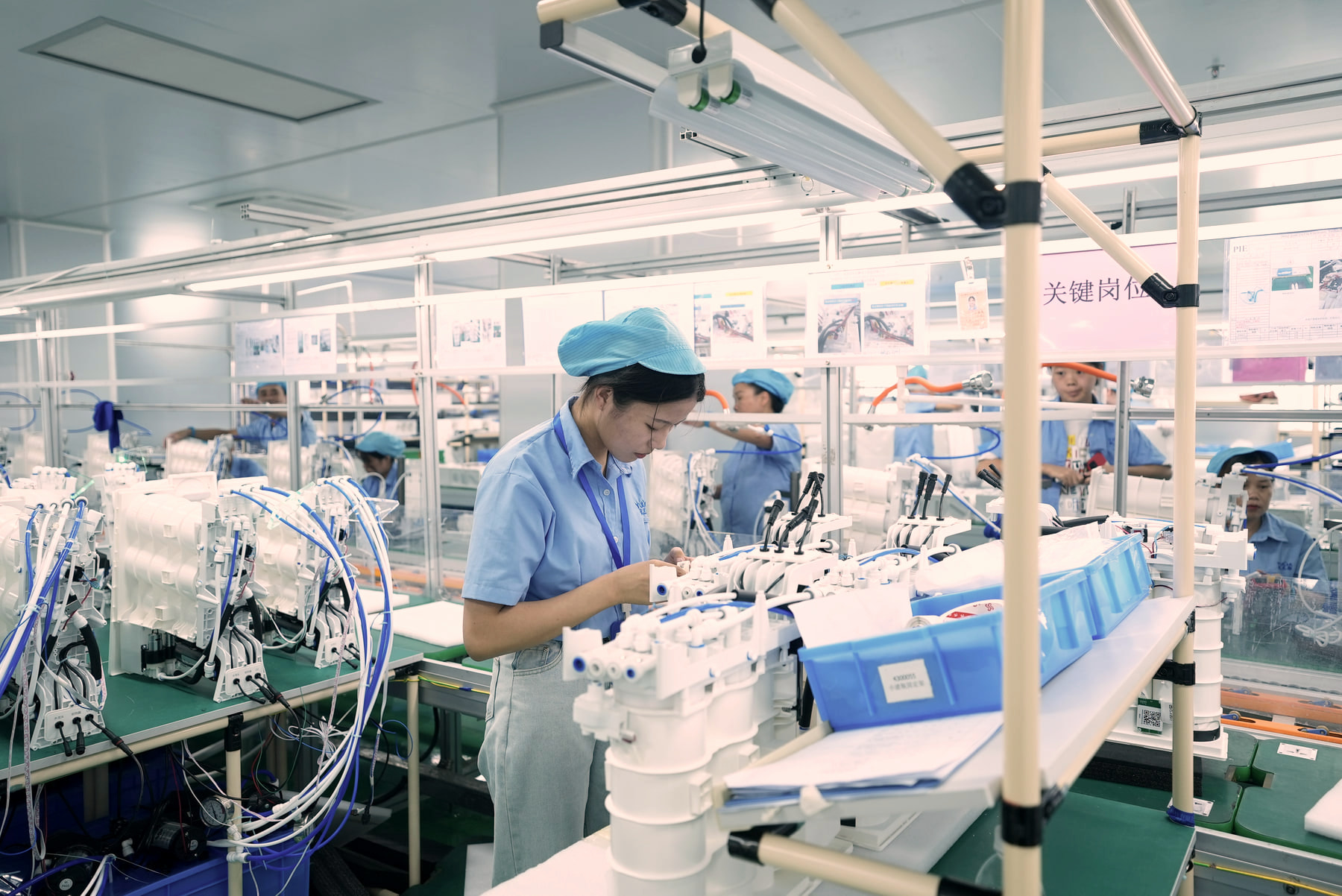 Operator completing standardized assembly work on water purification components.