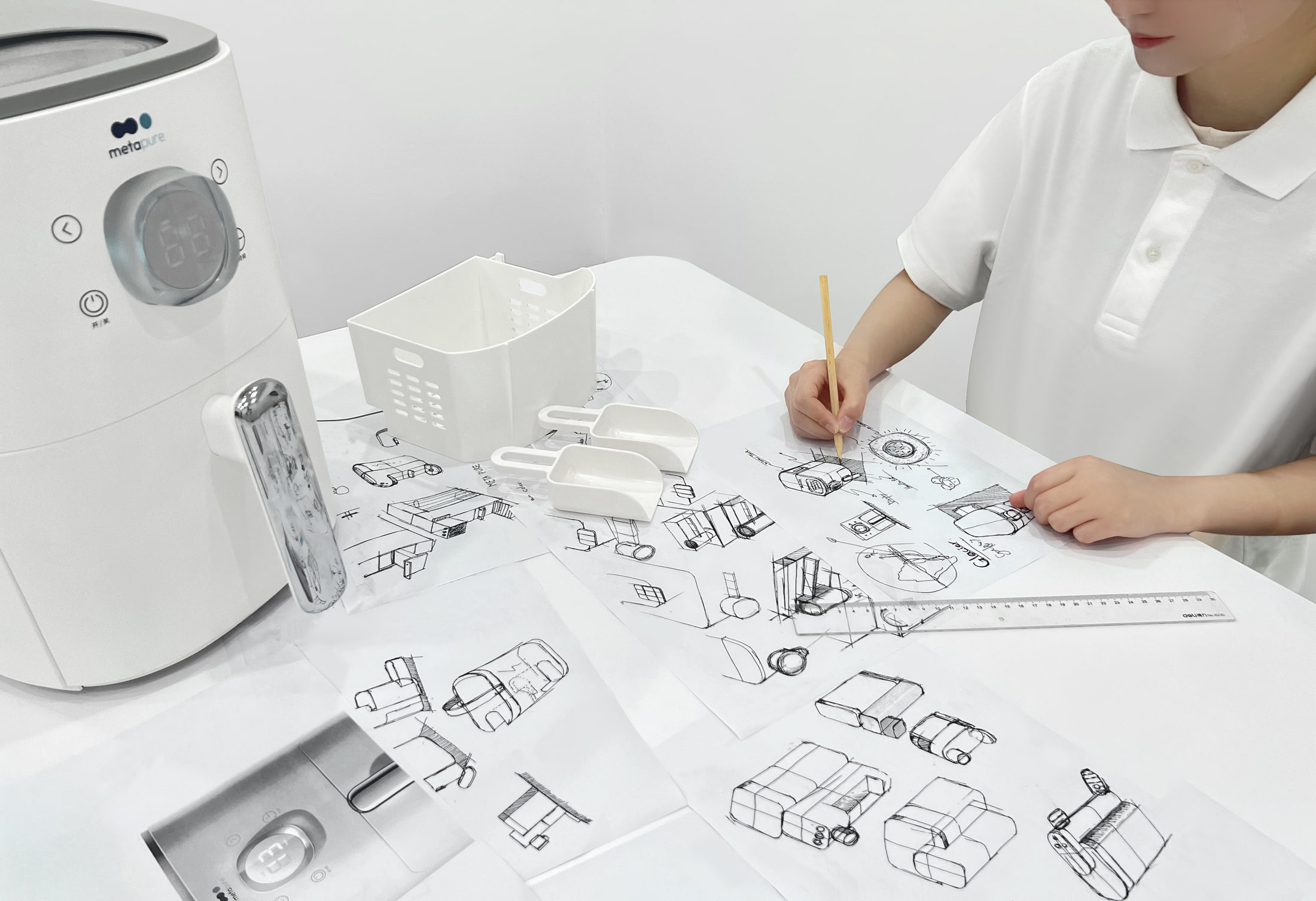 An industrial designer sketching a Metapure water appliance and its components.