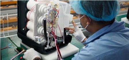 A technician performing an internal filtration and final-assembly inspection.