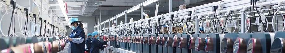 A long in-line test station where technicians inspect assembled water appliances.